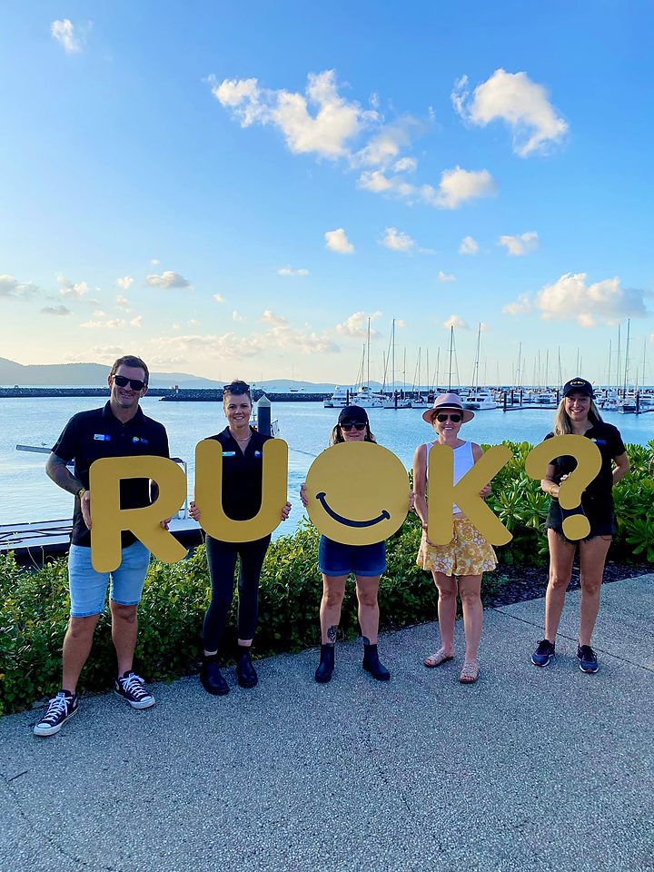 Network members holding R U OK? letters at the marina