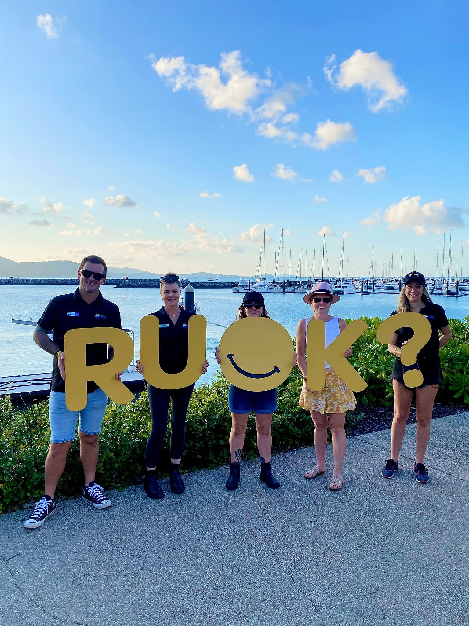 Network members holding R U OK? letters at the marina
